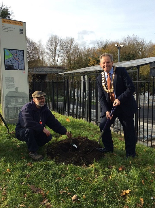 the Mayor planting a rose bush outside the station